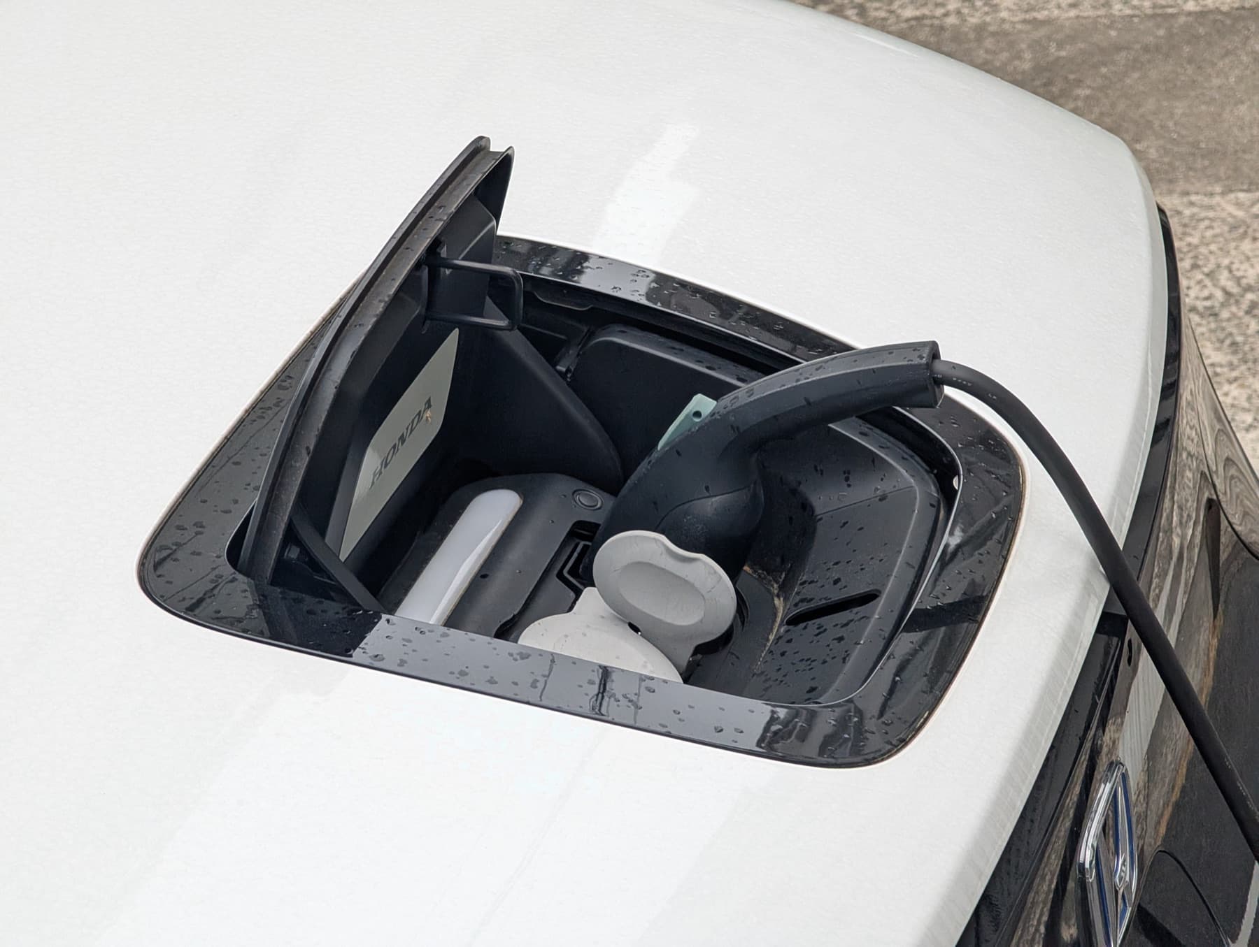 A charging cable plugged into an electric car's charge port.