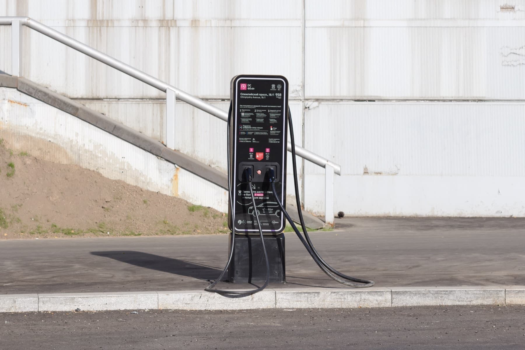 A dual-cable public DC charger standing on its own at a kerb.